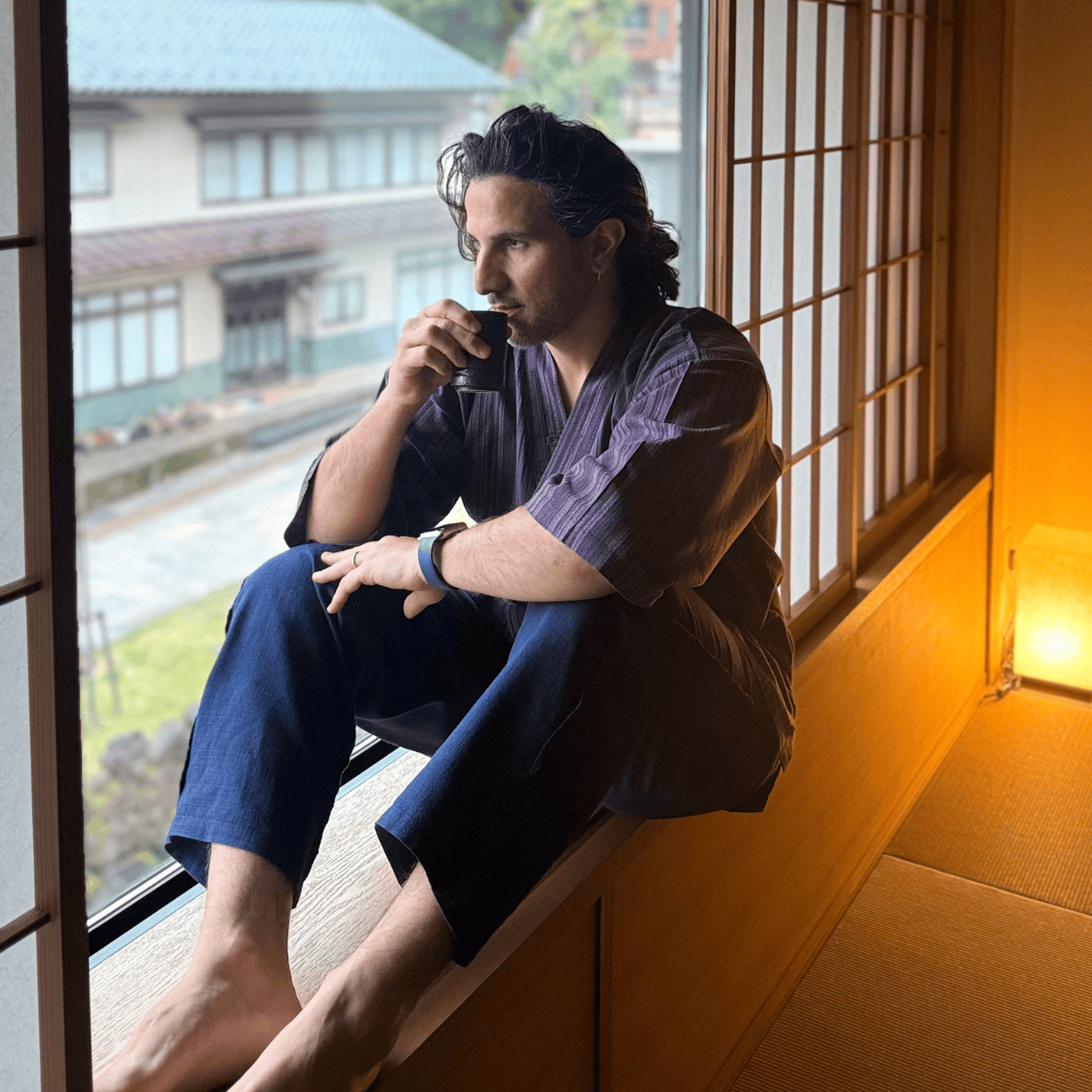 Morris, in jimbei, sorsessa un te davanti alla finestra di un ryokan
